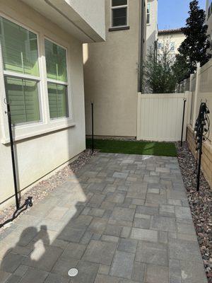 Pavers with turf. Rocks around the perimeter to fill with landscaping later.