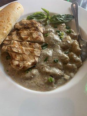 Grilled chicken with a creamy mushroom sauce over gnocchi