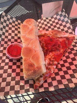 Slice of meat lovers and a breadstick with marinara sauce.