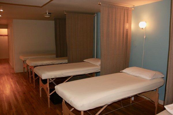 Treatments are given in a relaxing open space with curtains separating massage tables