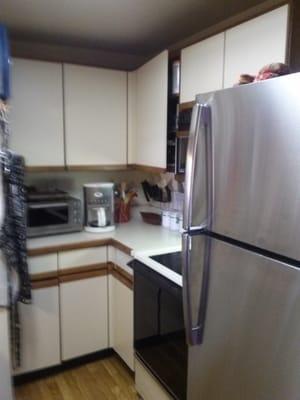 My 57-square foot kitchen "before". Cupboards falling off hinges, minimal counter space, poor lighting.