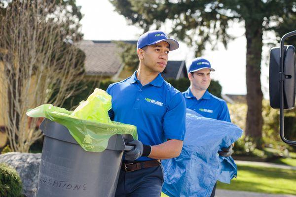 1-800-GOT_JUNK? Truck Team Members carrying trash cans