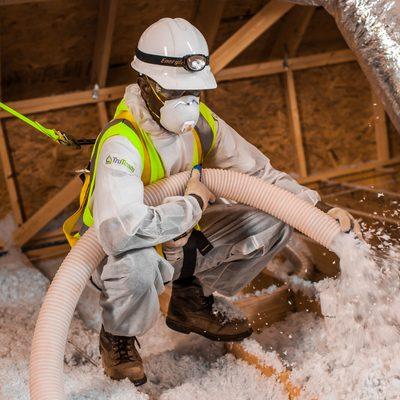 We specialize in a wide range of insulation products. Depicted is an installer putting blown-in insulation in an attic.