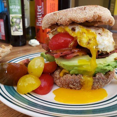 Avocado toast with marinated tomatoes, Turkey bacon and egg over easy on the whole grain english muffin