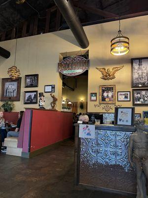 Brick House sign, hostess stand and a booth in the restaurant.