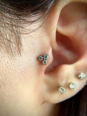 Tragus piercing with Titanium Trinity with Clear Cubic Zirconia Prongs by Adamant Body Jewelry.