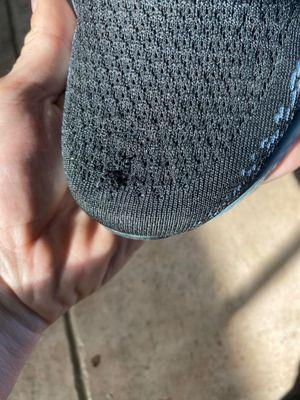 Hole in the mesh on the top of the left shoe