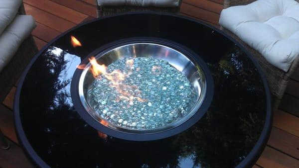 This image shows an outside fire pit with glass pebbles in place of fire logs, there are a variety of options and colors for ...