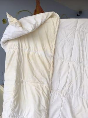 This comforter was pristine white,  kept under a duvet. These marks are burn marks.