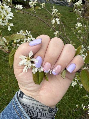 Trendy spring nails with periwinkle blue polish, French tips and flower nail designs