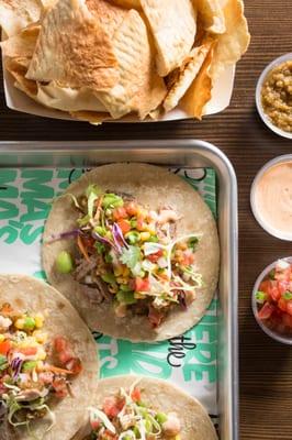 Three corn tortillas with braised pork shoulder, pico de gall, crunchy cabbage slaw, roasted corn, edamame, salsa rosa & lime crema. Wowzers