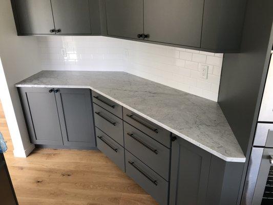 Countertops in Honed White Carrara Marble. White Subway tile splash.