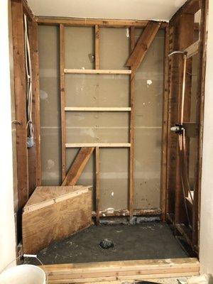 Master walk in shower in-progress with custom shelves.