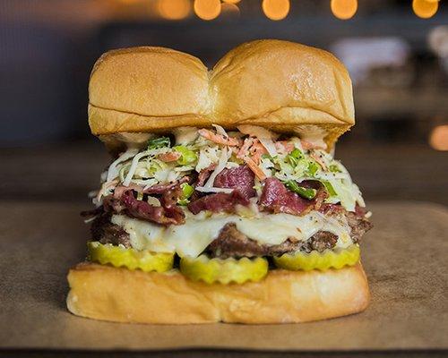 THE MENSCH - white american cheese, pickles, pastrami, haus slaw, secret sauce