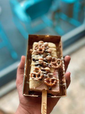 Pavlova Ice Cream Pop with pretzels, white chocolate dip, Dark Chocolate Crisps, and caramel drops