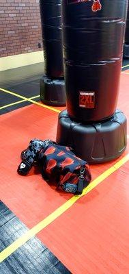 My beloved 18oz camouflage boxing gloves, my custom made gym bag laying next to the punching bag.