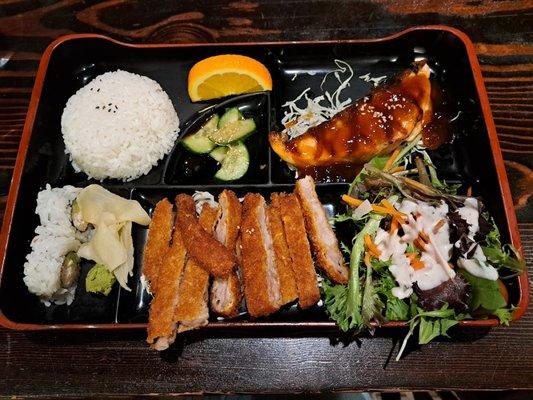 Bento Box with Salmon Teriyaki, Tonkatsu, Salad, Rice, Cucumber Sunomono, and 2 piece California Roll