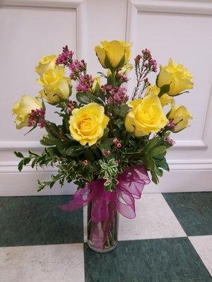 Dozen yellow roses with pink waxflower