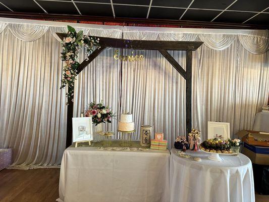 White background draping and wooden arch is provided