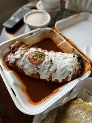 Birria wet burrito with red sauce combination (beans and rice on the side)