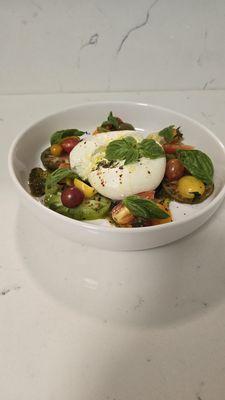 Buratta salad with pesto sauce with colorful tomatoes and fragrant basil