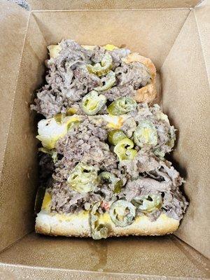 Cheesesteak with copper sharp and  jalapeño on a seeded Sarcone's roll.