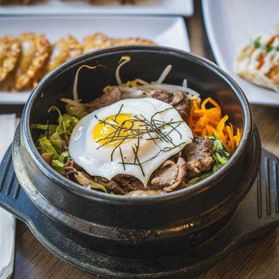 Bibimbap. Bowl of steamed rice topped with sautéed vegetables, fresh greens &amp; sunny side up egg, served with our signature gochujang.