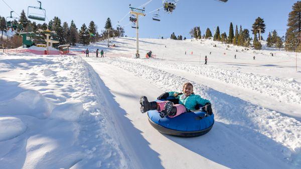 Smile for days as you race down the winter tube lanes at Grizzly Ridge Tube Park.