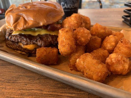 Smash burger with bacon added and a side of crispy tots