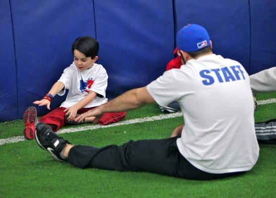 Coach Rob stretching out our baseball players before class begins