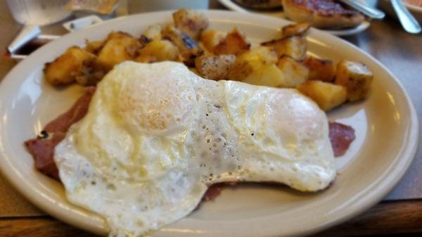 Eggs over easy with sliced  corned beef and grilled home fries.