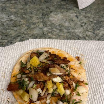 This is suppose to be a pastor taco.... It is actually a dry disgusting pork jerky taco with paper slivers of pineapple....