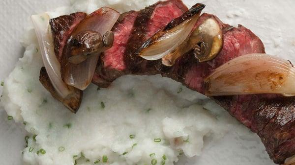 Pan roasted Hangar steak basted with thyme and rosemary served with roasted mushrooms and shallots in a caramelized onion demi.