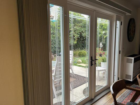 French doors that open to the back yard with small narrow windows on each side that open individually.