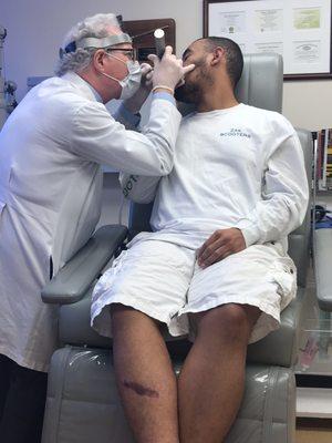 Dr. Finerman looking into one of my nostrils post-op and removing any gunk left in there.