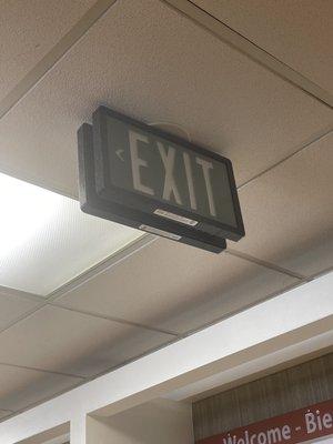 Exit sign is covered in dirt and dust in the ER waiting room