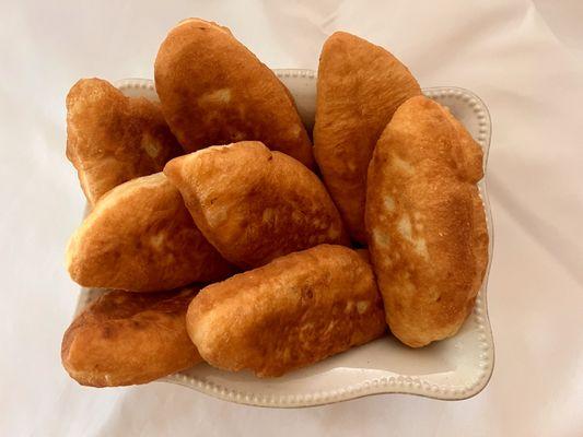 Pirozhki, fried yeast dough filled with cabbage, eggs &cheese or jam