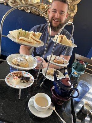 Two sets of afternoon tea (3 sandwiches cut in half, a scone with chantilly cream, 3 small desserts, a pot of tea).