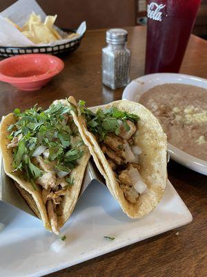 Grilled chicken tacos w/ onions, cilantro, and refried beans.