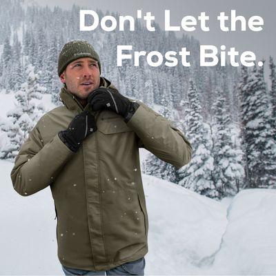 A man prepares for a 2025 winter storm in a Columbia jacket and gloves, surrounded by snowy trees. Gear up for the cold at Sun & Ski Sports.