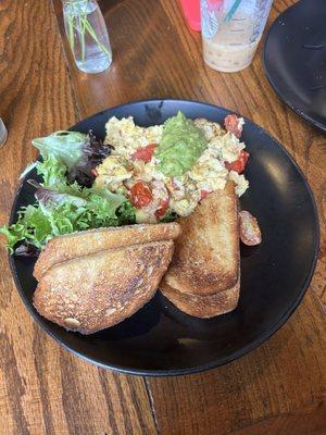 Veggie scramble with Guac, cheddar cheese and greens.  Sourdough toast.