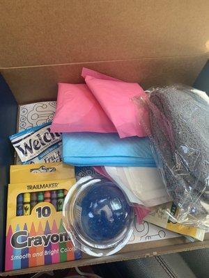 Box consisted of pads, cozy socks, jelly stress ball, tea, fruit snacks, granola bar, crayons and a coloring page