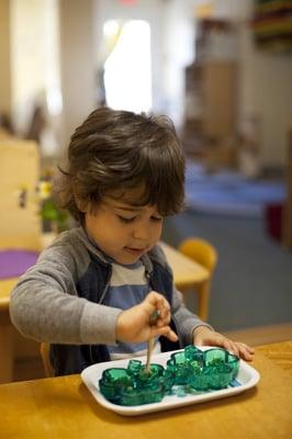 Toddler working a practical life activity