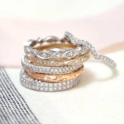 An assortment of women's wedding rings with hand engraving and diamonds. White gold, yellow gold, rose gold, and platinum.