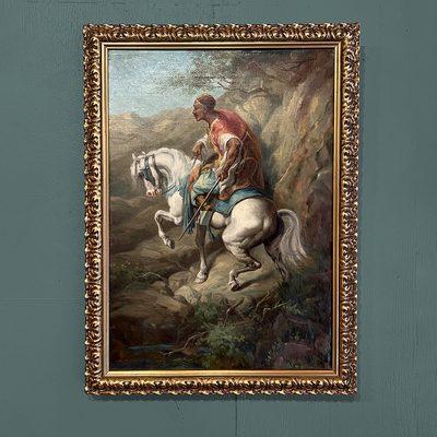 An ornate gold frame on an oil painting of a person on horseback.