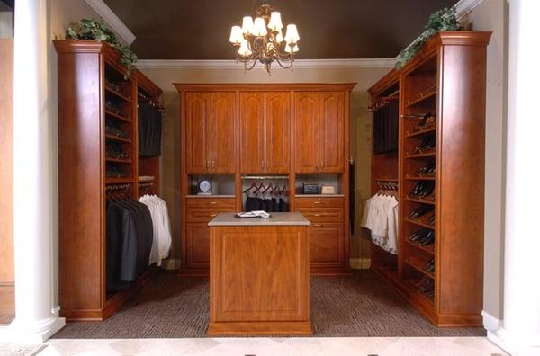 Wood tone walk in closet with island, flutes, and rosettes