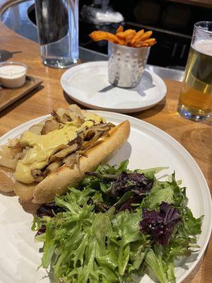 Philly cheesesteak with side of salad and sweet potato fries