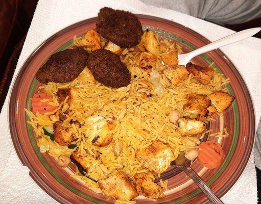 Chicken tikka with rice and a few falafel balls on the side. Salad is underneath the rice.