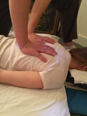 Palm pressure along the shiatsu meridian to relieve back tension.