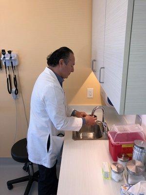 Dr. Newman in action washing his hands before and after seeing a patient.